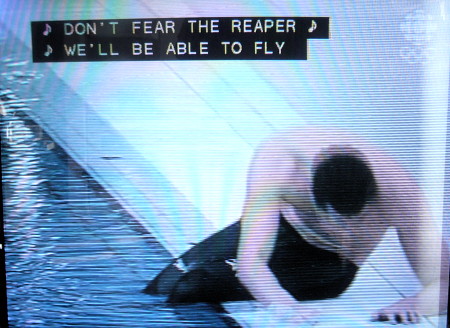 Swimmer barely holds himself up by the edge of a pool. Caption: ♪ DON'T FEAR THE REAPER ♪