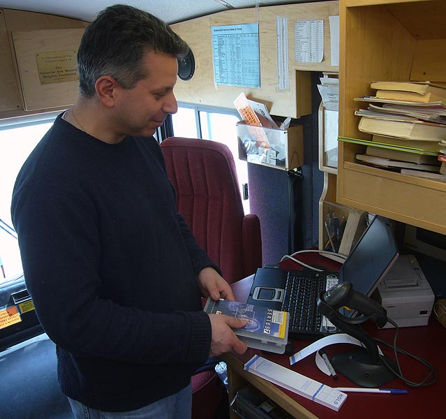 Male librarian checks in a videotape