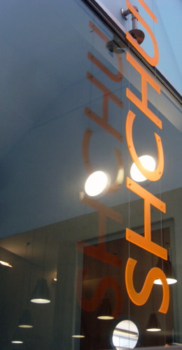 Peach-coloured Gill letters read SHCHU and hover on top of a window