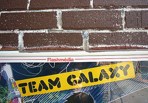 Team Galaxy Top of banner inside Flashm dia frame and below a brick wall 