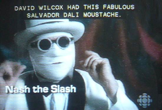 Nash the Slash, face completely bandaged, in round black shades, and wearing a white hat: David Wilcox had this fabulous Salvador Dalí moustache