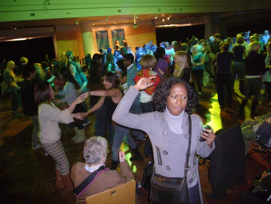 Black chick dances in green-lit atrium