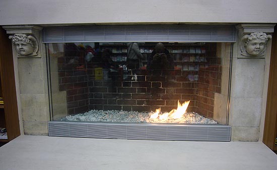 Fireplace with pebbled floor and small flame