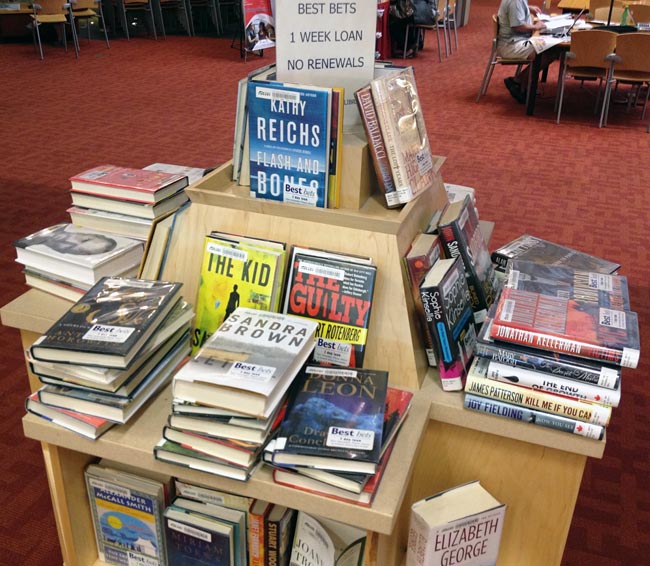 Books on Best Bets shelf piled face-up