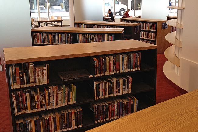 Three-shelf-high wooden shelving units arranged in a quarter-circle