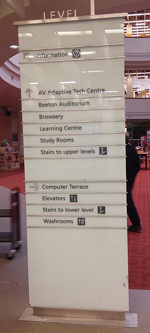 Seven-foot-tall white-glass sign with appliqué letters
