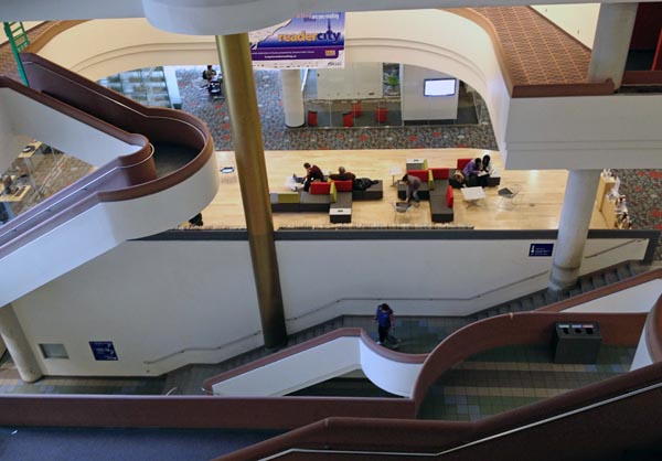 Curved staircases and recessed floors visible through atrium