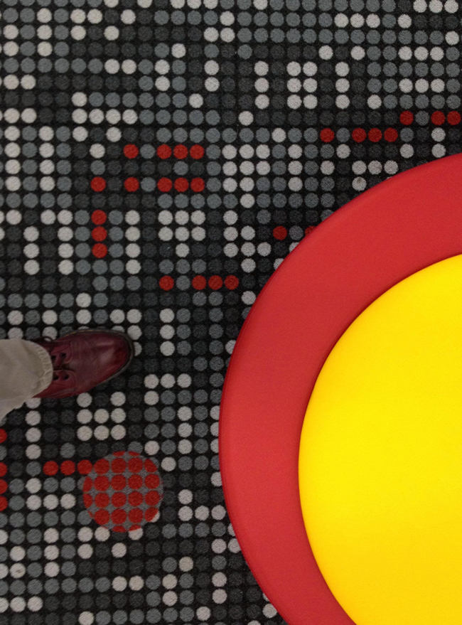 Black carpet with patterned dots; stool or concentric yellow and red circles