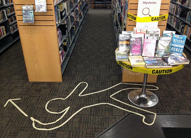 Outline of body on library carpet with arrow pointing to stacks