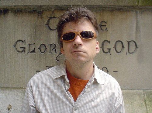 Man stands in front of inscribed marble wall