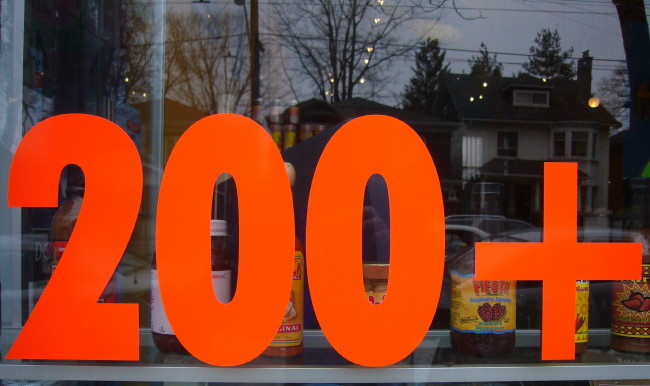 Vibrant orange type in a store window reads 200+