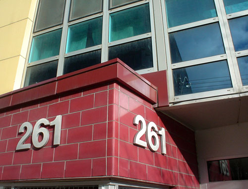 Windows and yellow wall tiles lead down to two angled walls in red tile labeled 261 in Helvetica