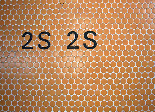 Type in Univers inscribed into a field of circular orange tiles reads 2S 2S