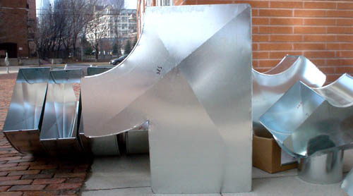Aluminum ductwork seated on a sidewalk resembles a numeral 1