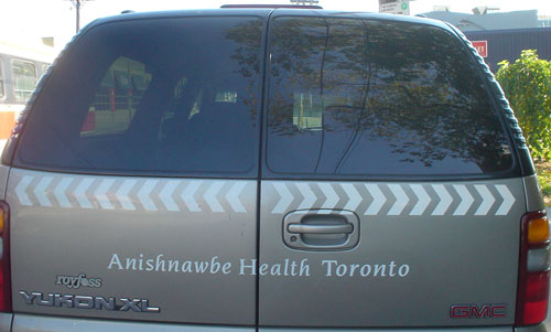 Dual ambulance doors of Suburban read Anishnawbe Health Toronto in Novarese Italic