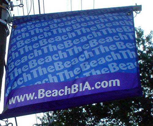Blue banner reads TheBeach continuously in diagonal type across the main face and www.BeachBIA.com at bottom