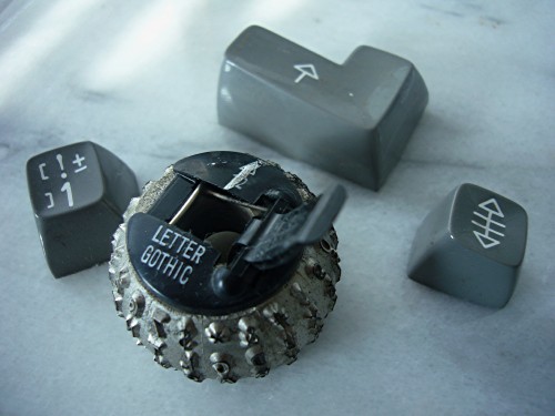 IBM Selectric typing element (Letter Gothic) and three Selectric keys (margin release, []1!±, L-shaped carriage return
