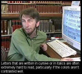 Screenshot of bearded man seated at large-screen monitor with enlarged text. Caption reads: Letters that are written in cursive or in italics are often extremely hard to read, particularly if the colo[u]rs aren’t contrasted well