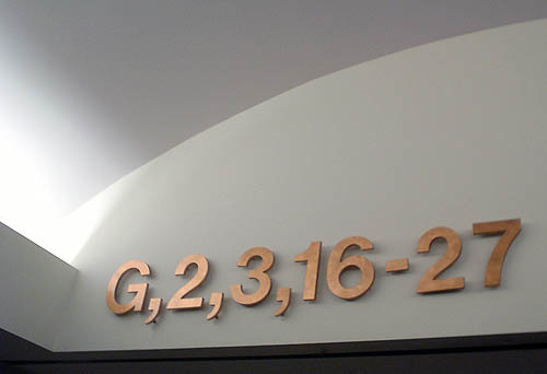 Brass Helvetica characters on bottom edge of wall read G,2,3,16-27