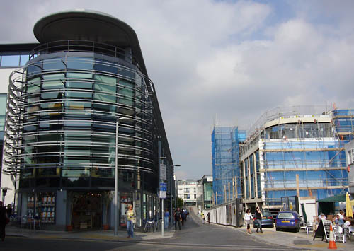Modern glass building has projecting glass platforms each rounding a curve at the building’s end