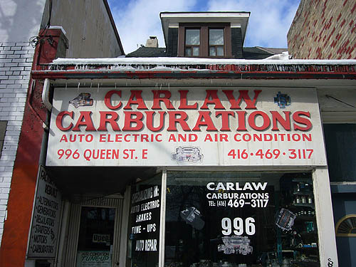 Storefront with tidy cutout wooden letters on sign reading CARLAW CARBURATIONS