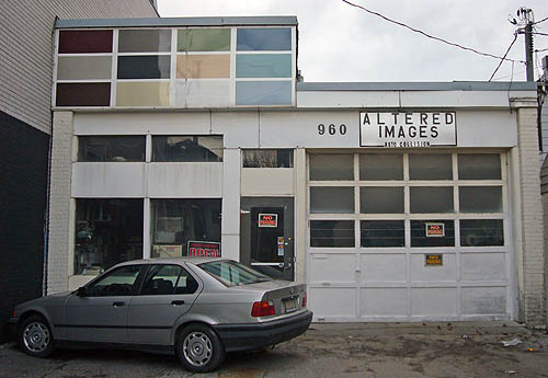 Altered Images Auto Collision storefront has parked BMW and, projecting from the roof, twelve pastel-coloured panels