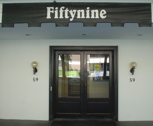 Doorway is flanked by torches and the number 59. Above the doorway sits a banner reading Fiftynine in Belwe Condensed