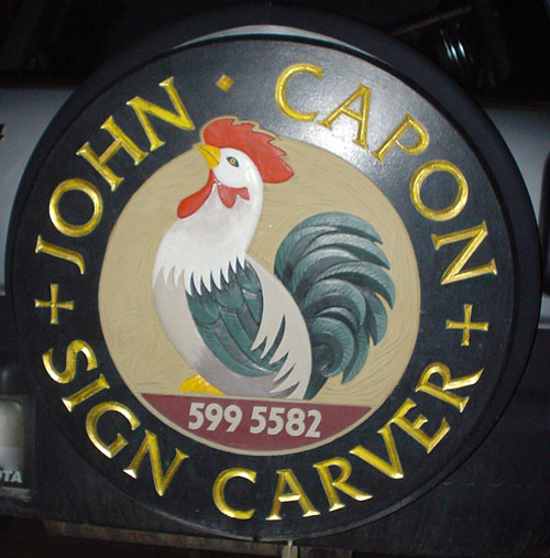 Exterior spare-tire cover shows a rooster encircled by the legend JOHN CAPON + SIGN CARVER in engraved Friz Quadrata