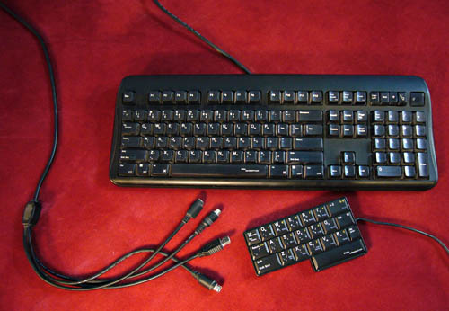 Full-sized black keyboard with cable terminating in four ends, plus tiny L-shaped keyboard