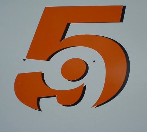 Sign in Helvetica shows a 9 carved out of negative space inside a 5