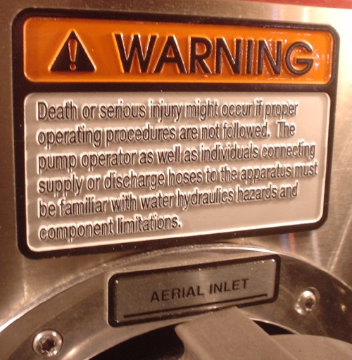 Sign in raised type reads WARNING in Avant Garde Gothic, with a full paragraph of warnings about death or serious injury in Helvetica Condensed