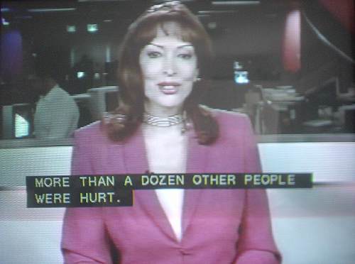 Raven-haired woman in low-cut red blazer (also with visible captions)