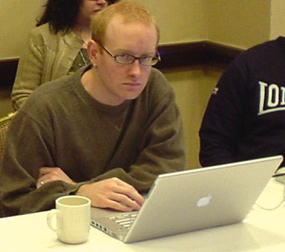 Red-haired man looks up from PowerBook