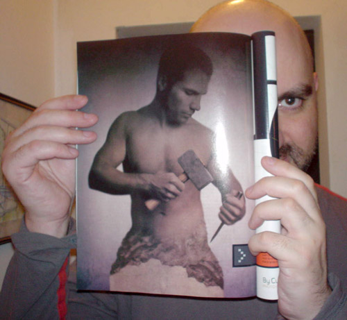 I hold a copy of ‘Esquire’ showing a chiaroscuro image of shirtless man chiseling himself from a column of stone