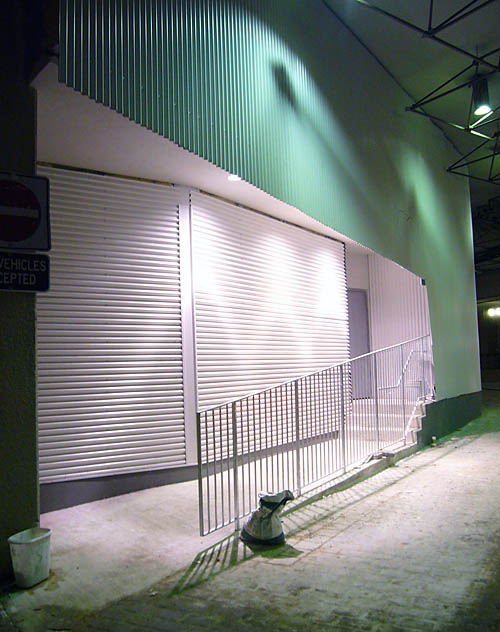 Exit door sits at the top of a small staircase inset in white and green corrugated metal walls