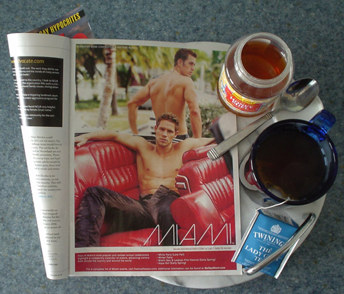 Magazine ad (next to blue teacup and honey jar) shows shirtless man lounging in red-upholstered convertible with the legend MIAMI