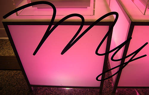 Script type on window before glowing pink display case reads My