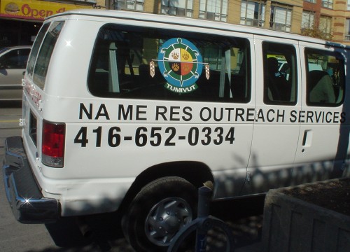 Van is labeled NA ME RES OUTREACH SERVICES in Arial (with phone number in Helvetica Condensed)