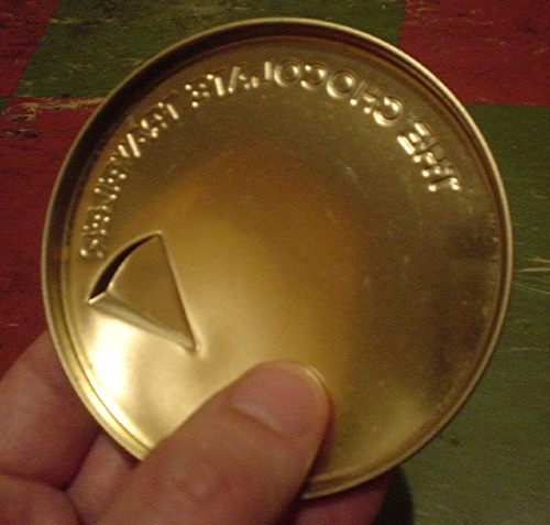Brass-coloured inside of tin lid reads THE CHOCOLATE TRAVELER in reverse Insignia type