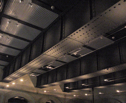 Thick, riveted I-beams line a ceiling