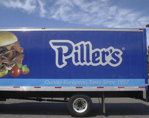 Blue truck shows a smoked-meat sandwich on a kaiser and reads Piller in flowing handwriting-like blackletter type. ‘Quality European Taste Since 1957’ is written along the bottom in sloped Eras type’