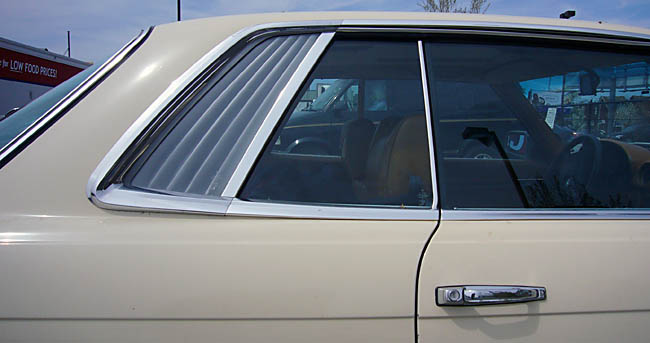 Louvred trailing edge of rear window of cream-coloured Mercedes SLC