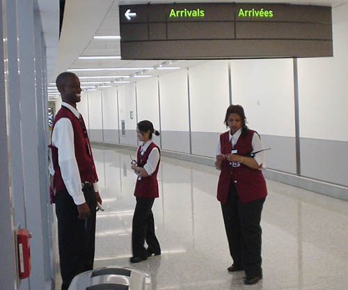 Sign reads ← Arrivals Arrivées and points at a wall (seen edge-on)