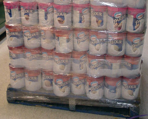 Skid of red-capped Parlour ice cream tubs sits imperfectly cocooned in plastic