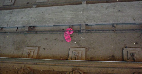 Pink Slinky sits on dun-coloured track ties