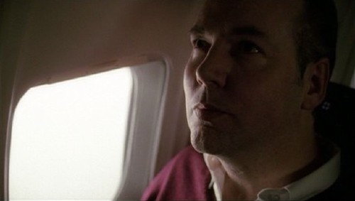 Coupland looks straight up while seated alongside an airplane window