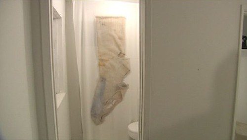Giant photo of chewed-up, stained sock on bathroom wall