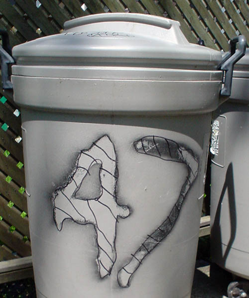Grey plastic garbage can has burned-in numeral ‘47’ in a crosshatched pattern