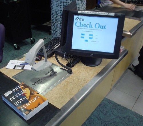 Book ‘Graphic Design 20th Century’ sits on flat black pad alongside scanner in cradle and touchscreen display