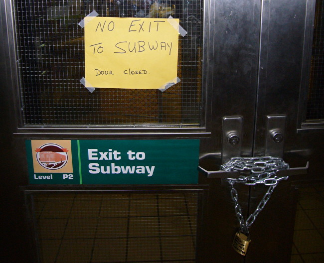 Sign on door: Exit to subway. Scrawled sign taped to window: NO EXIT TO SUBWAY DOOR CLOSED